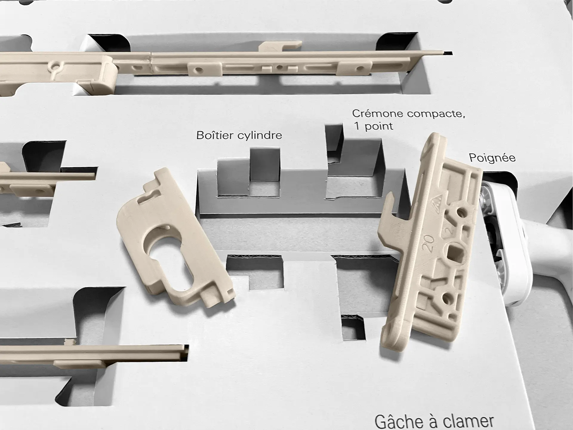 Präsentationsbox zur Produkteinführung von Beschlagteilen in der Fenster- und Türtechnologie. Detailbild: sicherer Halt für polymorphe Beschlagteile dank durchdachter Konstruktion und mittels der Klemmwirkung des Rohstoffs Wellpappe.